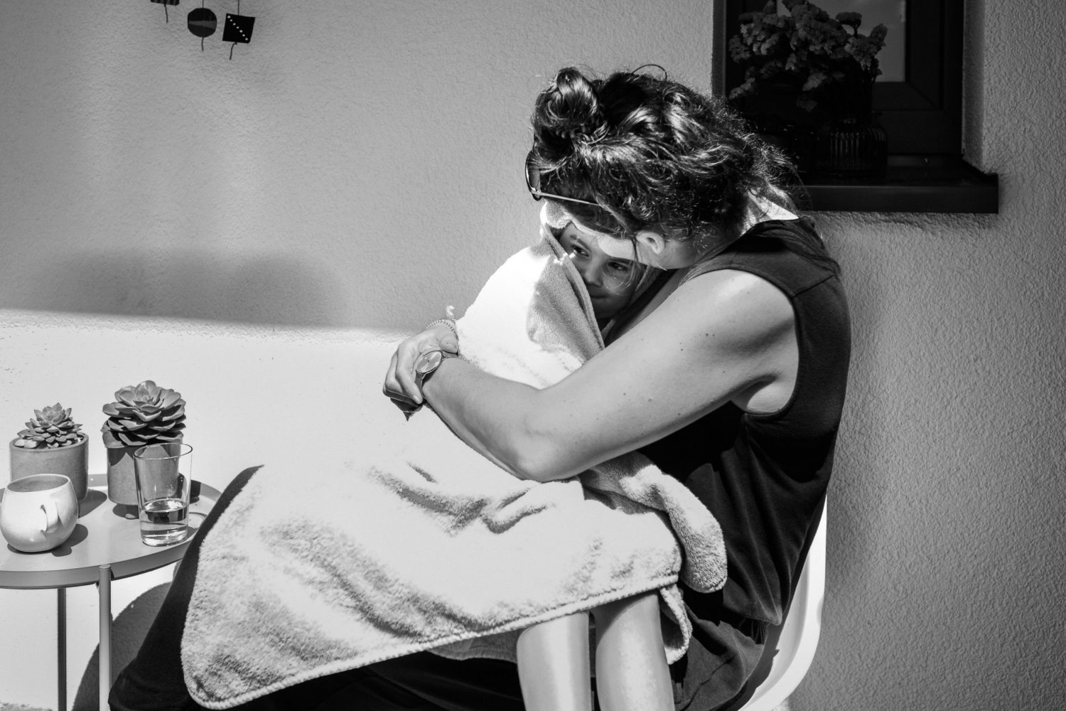 Mutter kuschelt mit ihrer Tochter die in ein Handtuch gehüllt ist