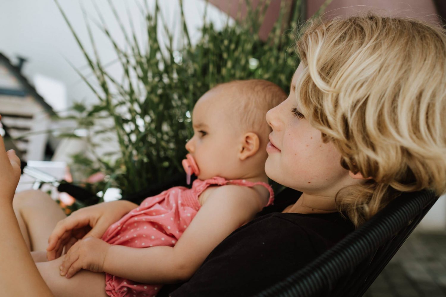 Geschwister umarmen sich auf Stuhl