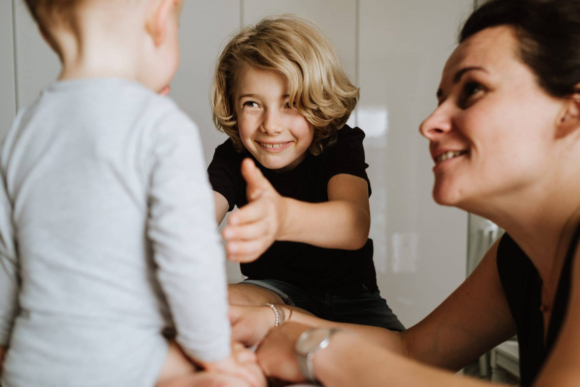 Kleiner Junge will seine kleinere Schwester in den Arm nehmen