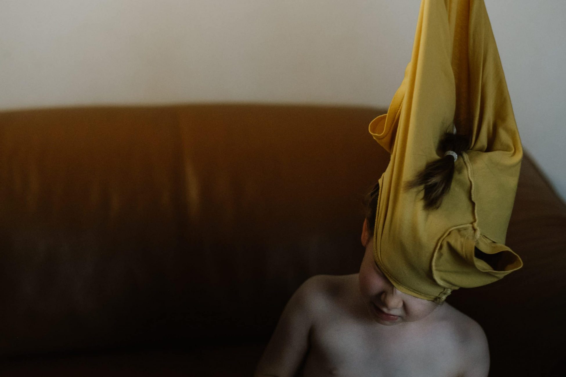 Einem Kind wird das T Shirt über den Kopf gezogen