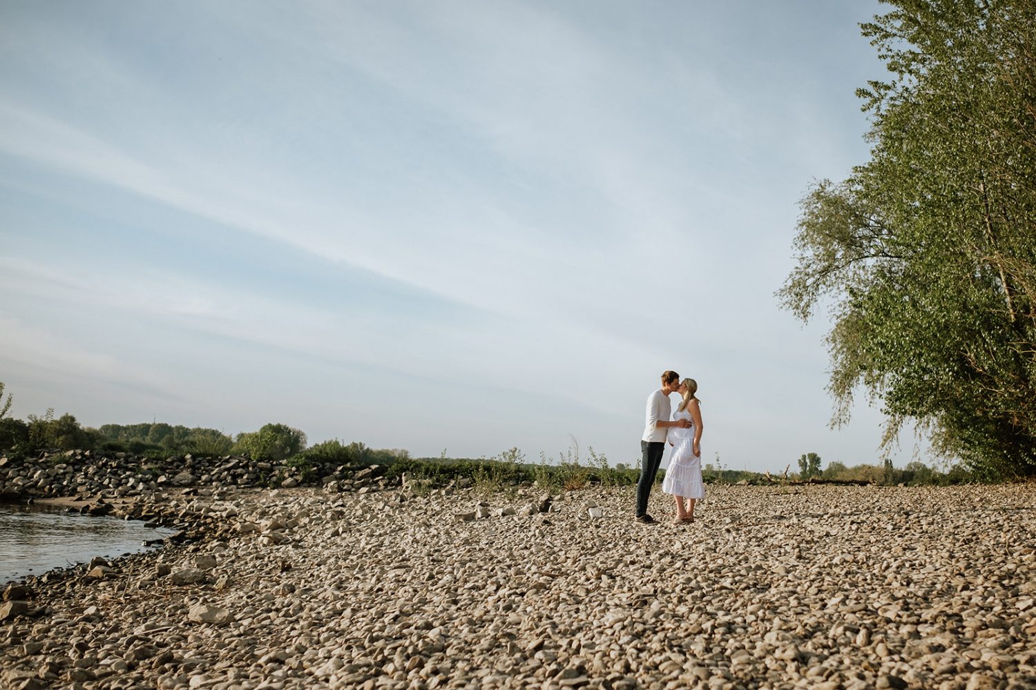 Babybauchshooting von einem Pärchen am Kieselstrand
