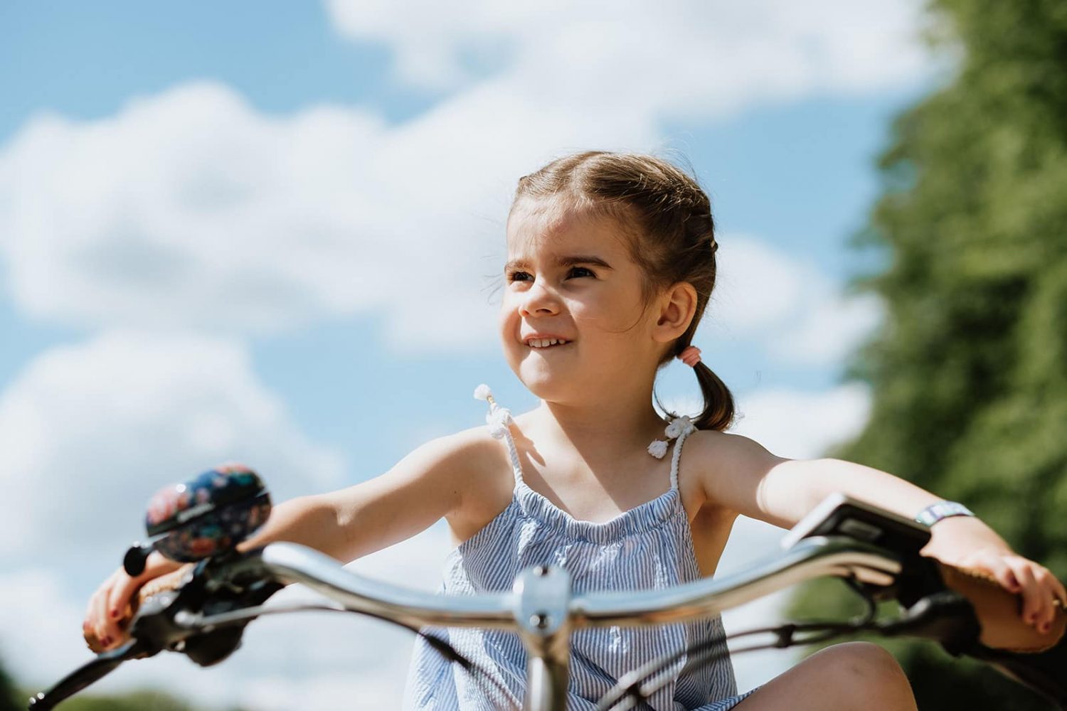 Kinderfoto eines kleines Mädchens auf dem Fahrrad im Sommer