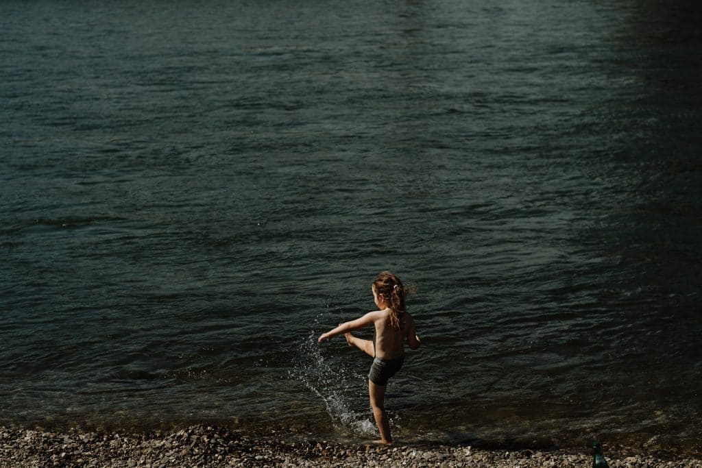 Mädchen spielt im Wasser am Rhein