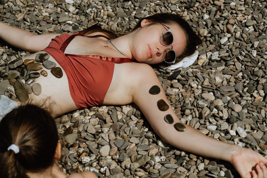 Kind spielt mit der Mama am Kieselstrand