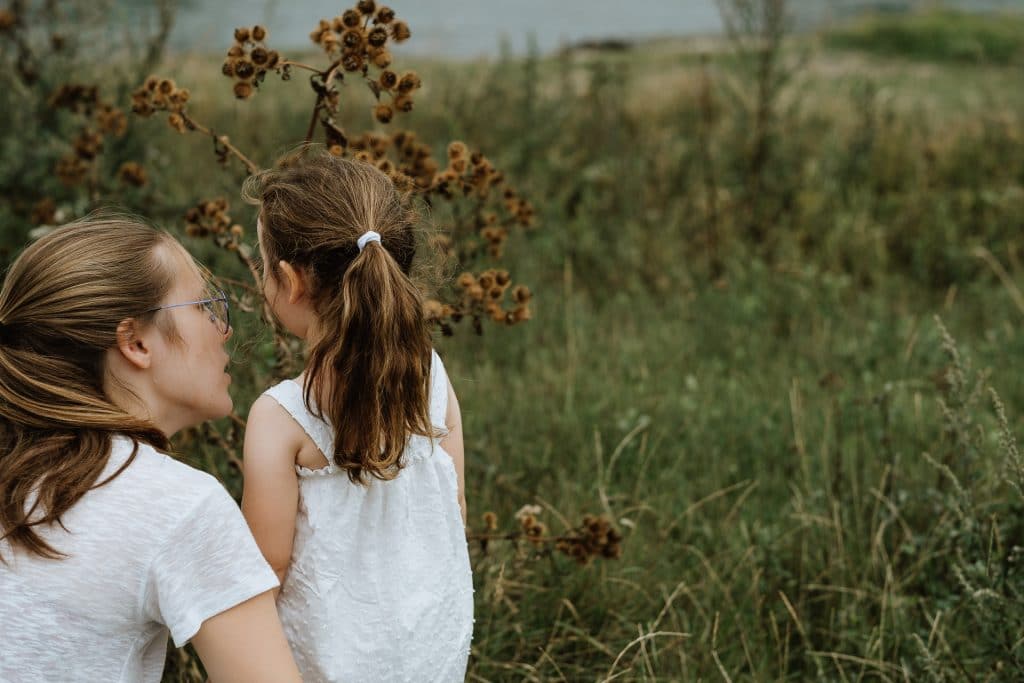 Mama und Tochter schauen sich eine Blumenwiese an
