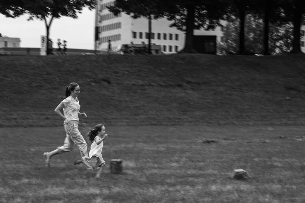 Mama und Tochter rennen über die Wiese