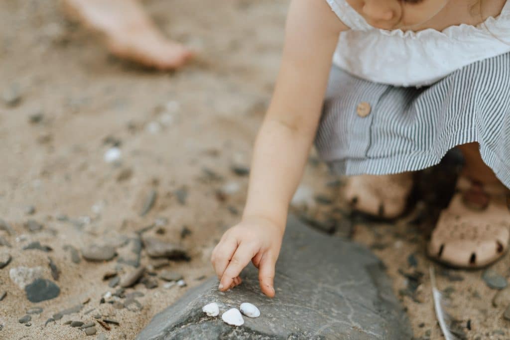 Mädchen sammelt Muscheln am Rhein