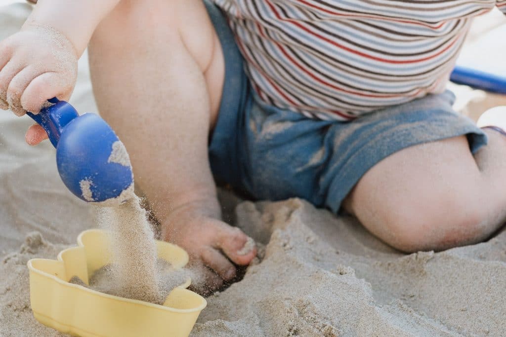 Kind spielt im Sand