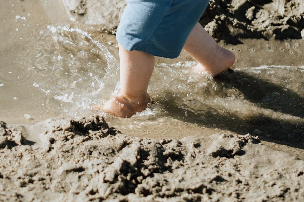 Kleinkindfüsse im Meer