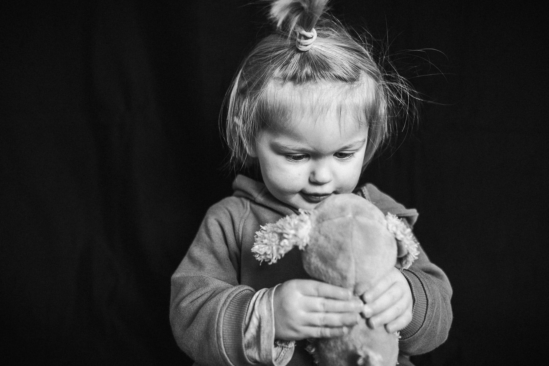 schwarz weiß portrait eines Kindes mit Kuscheltier