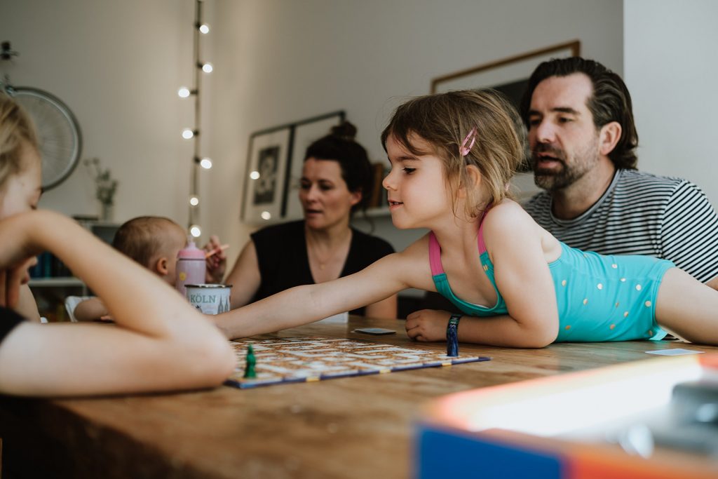 Familie sitzt am Tisch und spielt