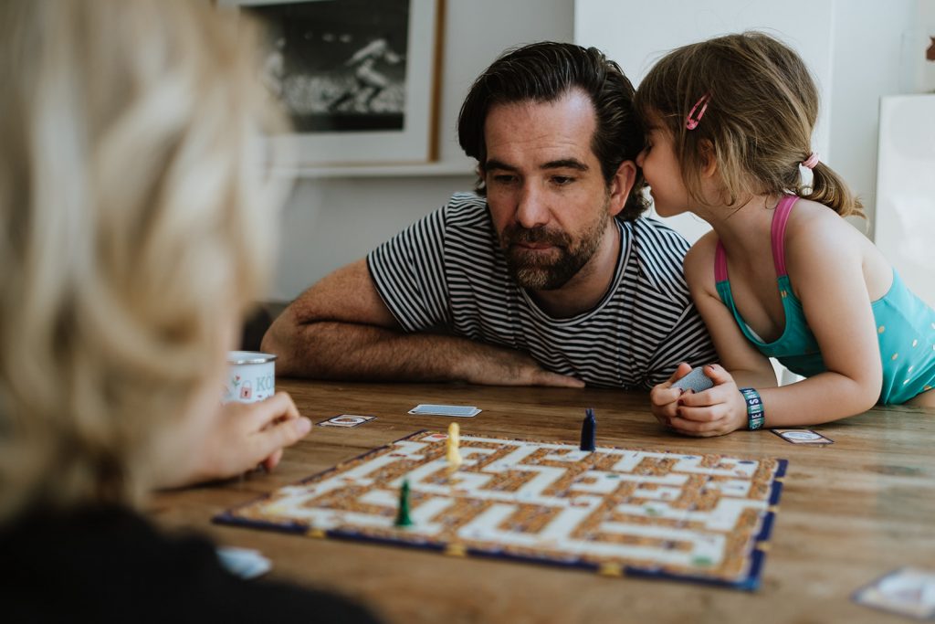 Papa spielt ein Gesellschaftsspiel mit seinen Kindern
