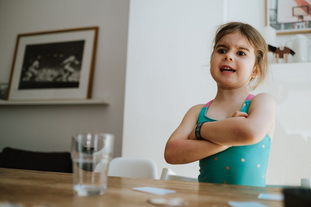Kleines Mädchen steht mit verschenkten Armen da