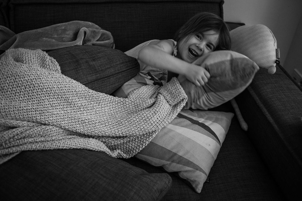 Kleines Mädchen liegt auf dem Sofa