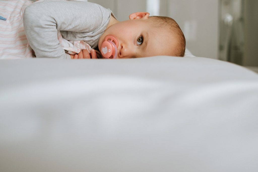 Kleines Baby liegt auf einem Bett