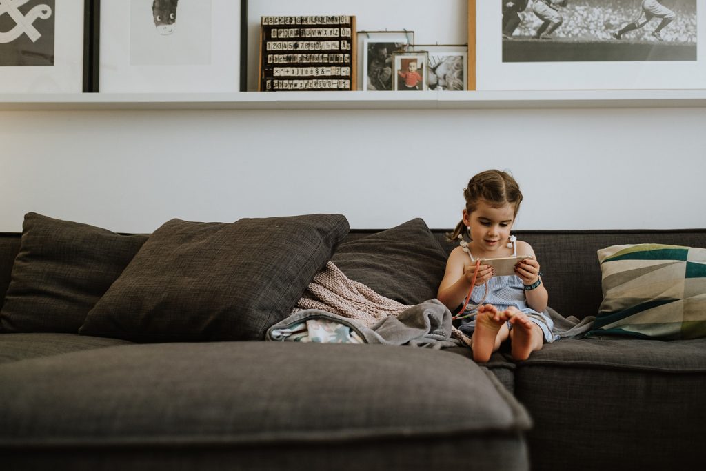Kleines Mädchen sitzt auf der Couch
