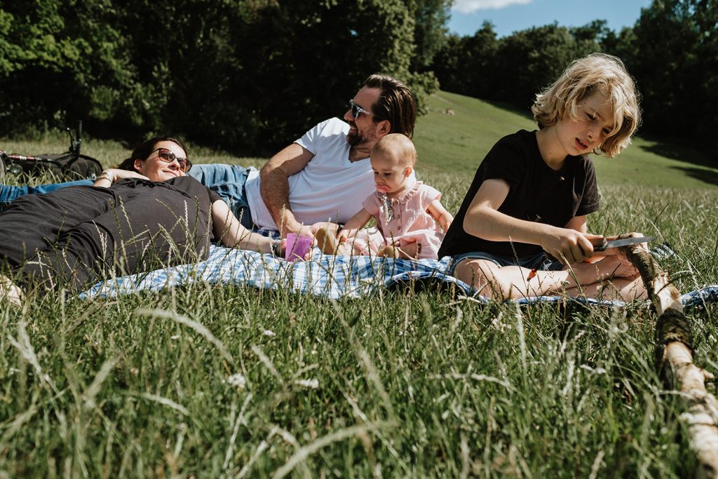 Familie sitzt auf der Decke im Park