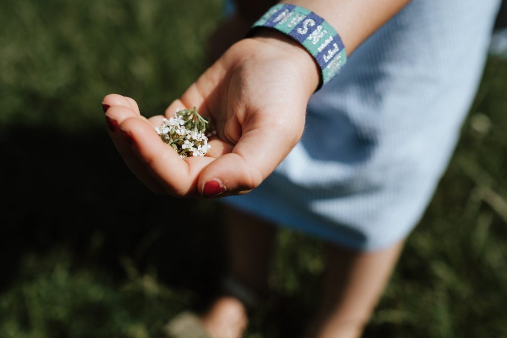 Nahaufnahme von Kinderhand mit Blumen